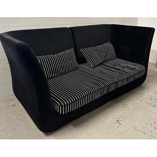 148 - A large black high backed sofa with black and white striped cushions (H105cm W240cm D108cm)