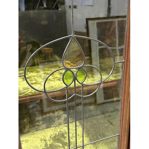 151 - An Art Nouveau style display cabinet with two green crushed velvet shelves and two stained glass pan... 