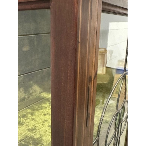 151 - An Art Nouveau style display cabinet with two green crushed velvet shelves and two stained glass pan... 