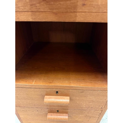 159 - A teak three drawer bedside table with central shelf and on castors (H78cm W47cm D43cm)