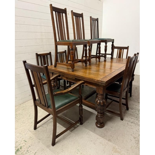 163 - An oak extendable dining table on carved acanthus supports with a harlequin set of ten faux green le... 