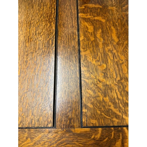 163 - An oak extendable dining table on carved acanthus supports with a harlequin set of ten faux green le... 