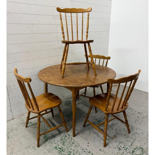 173 - A circular extendable dining table and four spindle back chairs (H72cm Dia110cm)