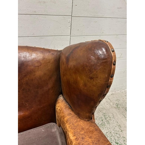 18 - A brown leather upholstered club chair with brass stud detail