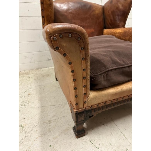 18 - A brown leather upholstered club chair with brass stud detail