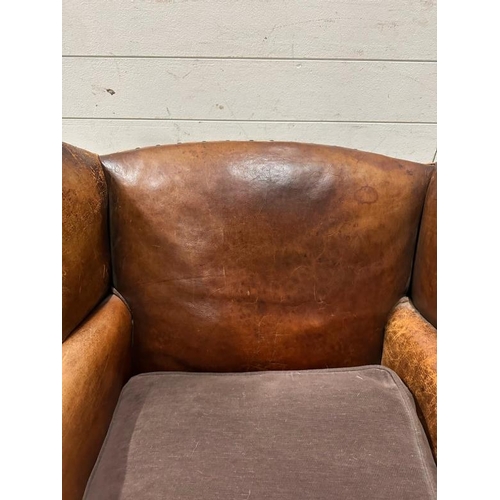 18 - A brown leather upholstered club chair with brass stud detail