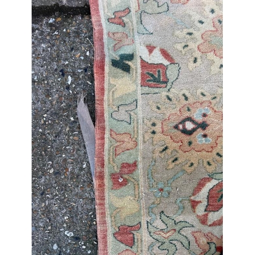 199 - A large wool rug, red grounds  with a floral pattern and floral geometric boarder (410cm x 307cm)