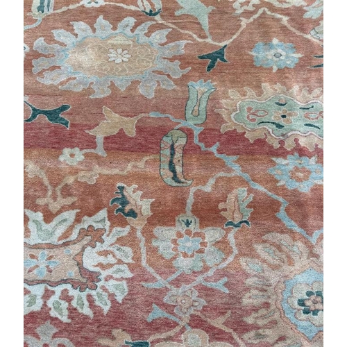 199 - A large wool rug, red grounds  with a floral pattern and floral geometric boarder (410cm x 307cm)