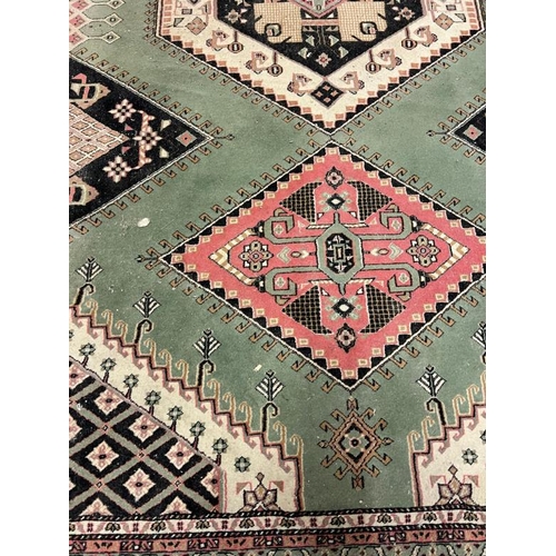 206 - A green ground rug with diamond design to centre 250cm x 160cm