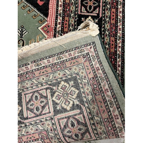 206 - A green ground rug with diamond design to centre 250cm x 160cm