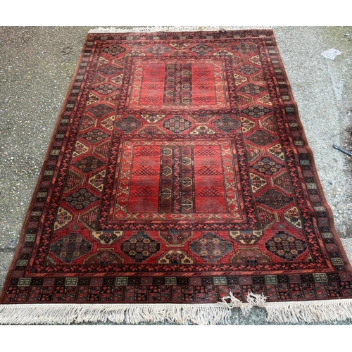 209 - A wool rug, red grounds with a geometric boarder 260cm x 170cm