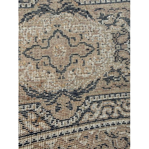 210 - A wool rug, brown grounds with central medallion and geometric boarder 200cm x 140cm