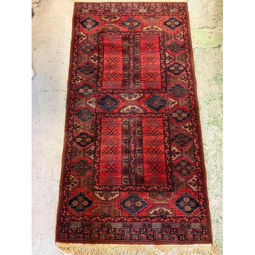 212 - A wool runner, red grounds with geometric border 107cm x 85cm