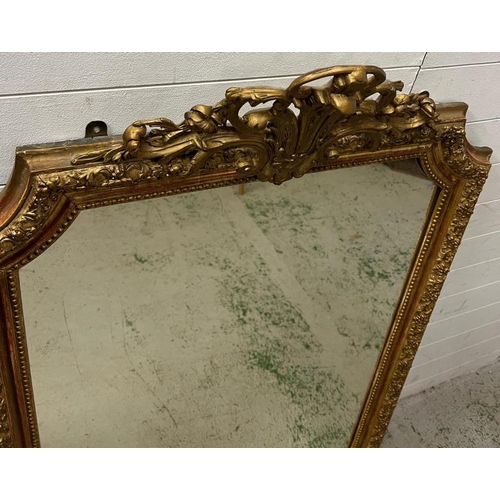 218 - A French giltwood mirror with scrolling crest, floral swags shaped mirror plate (150cm x 96cm)