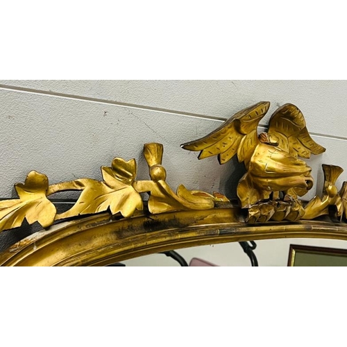 223 - A gilt frame large mantel or hall mirror, carved eagle with oak leaves sits upon an arch top and oak... 