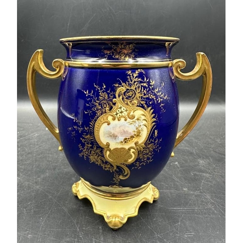 261 - A Coalport two handled vase, cobalt blue with gilt decoration and hand painted scenes. 13cm High