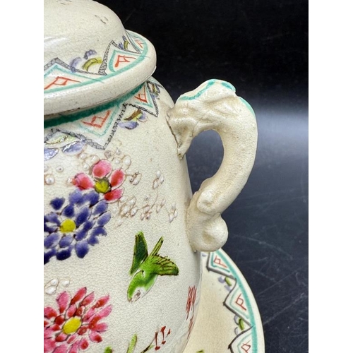 290 - A lidded jar on matching saucer with accent tassel handles and hand painted floral pattern