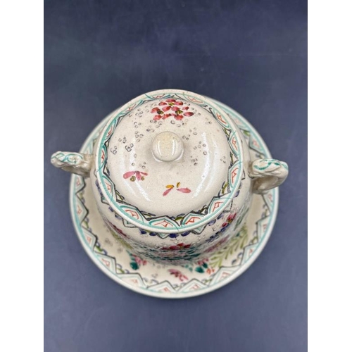 290 - A lidded jar on matching saucer with accent tassel handles and hand painted floral pattern