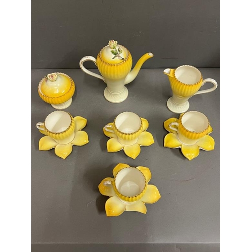 329 - A decorative coffee pot set, the porcelain China cups with rib sides and saucers in the form of flow... 