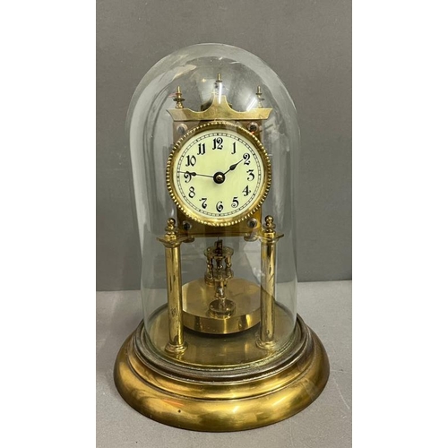 386 - A German Lorsion clock supported on two brass pillars with a glass dome