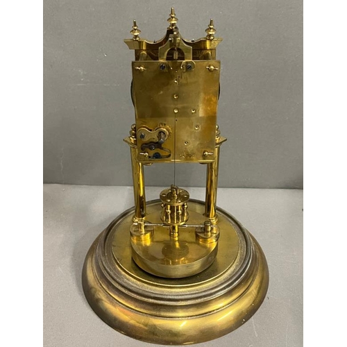 386 - A German Lorsion clock supported on two brass pillars with a glass dome