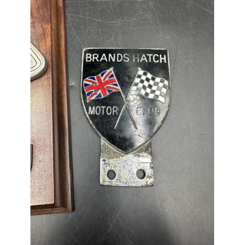 403 - Motorsport collectables, two enamel badges for the B.R.D.C and Brands hatch and a plaque of silver s... 