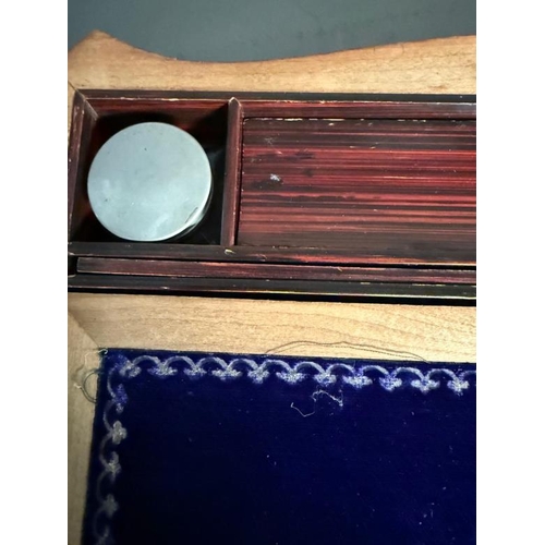 409 - A walnut writing slope with mother of pearl central inlay. The lid openning to a purple velvet writi... 