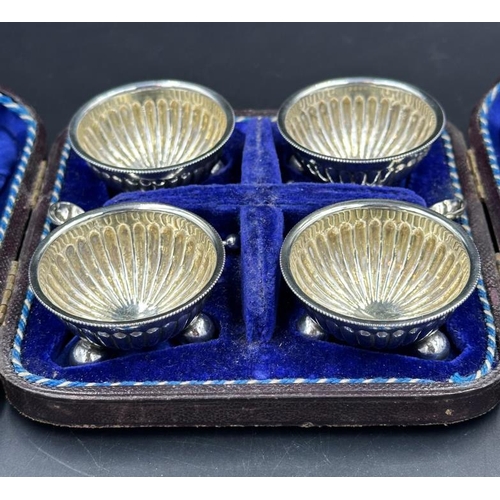 439 - A boxed set of four white metal salts and spoons, cased with blue velver liner