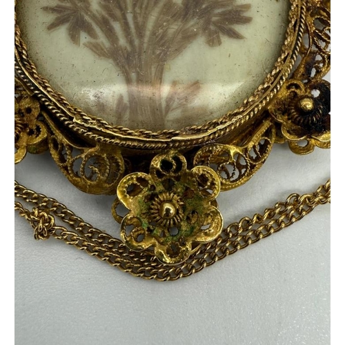 619 - A Georgian gold-coloured metal lovers eye painted pendant, oval with eye painting, on ivory, on a la... 