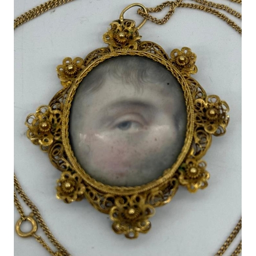 619 - A Georgian gold-coloured metal lovers eye painted pendant, oval with eye painting, on ivory, on a la... 