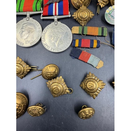 704 - WWII medals and additional insignia cap badges etc for the Dorsetshire Reg to include The Defence Me... 