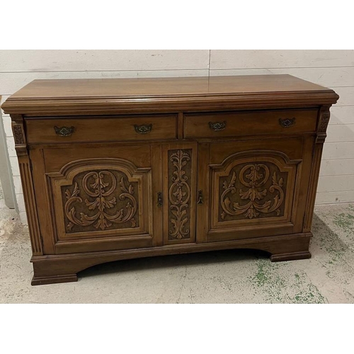 73 - An oak sideboard with two drawers and two carved panel doors below  (H97cm W150cm D54cm)