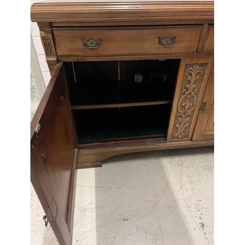 73 - An oak sideboard with two drawers and two carved panel doors below  (H97cm W150cm D54cm)