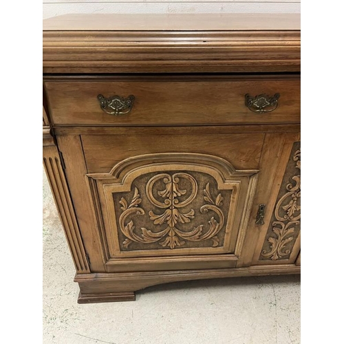 73 - An oak sideboard with two drawers and two carved panel doors below  (H97cm W150cm D54cm)