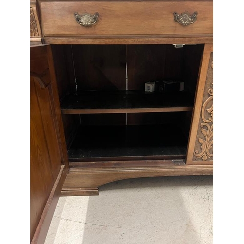 73 - An oak sideboard with two drawers and two carved panel doors below  (H97cm W150cm D54cm)