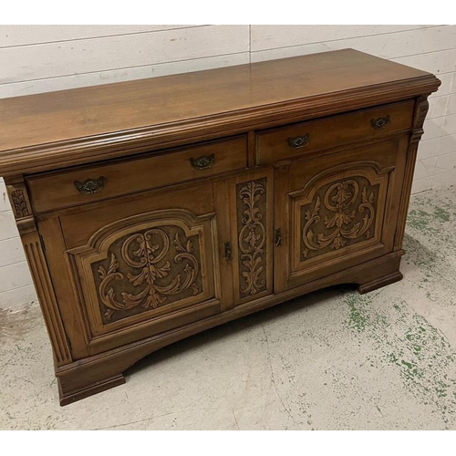 73 - An oak sideboard with two drawers and two carved panel doors below  (H97cm W150cm D54cm)