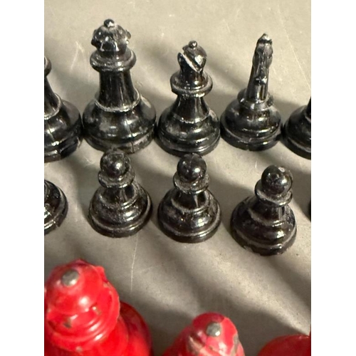 805 - A set of lead chess pieces in red and black