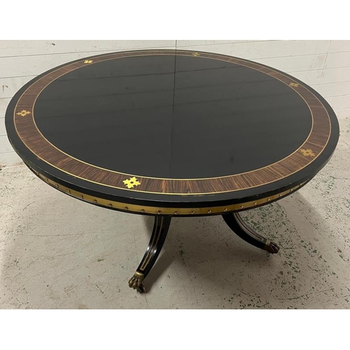 83 - Ebonised pedestal dining table with brass ornate decor  (H75cm Dia137cm)