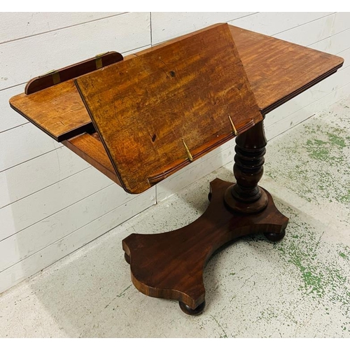 87 - A mahogany Revival twin reading table with a double book rest, adjustable turned stem on a solid bas... 