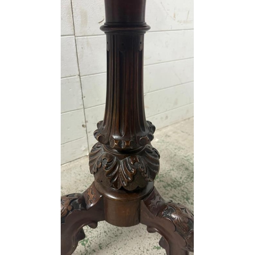 124 - A circular mahogany pedestal table on heavily carved splayed tripod legs and ending on castors (H72c... 