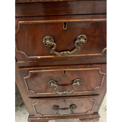 168 - A red leather topped pedestal desk, one long central drawer flanked by eight short drawers and on cl... 