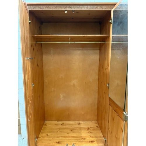 173 - A pine two drawer wardrobe with one long drawer under, the doors opening to cross rail and internal ... 