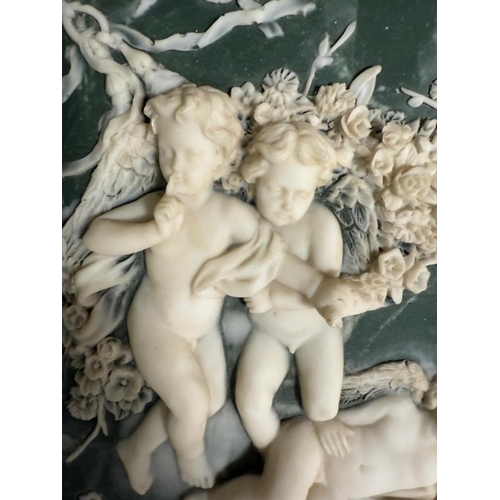 197 - A 20th Century neoclassical revival wall mirror having a ceramic panel to top featuring four putti w... 