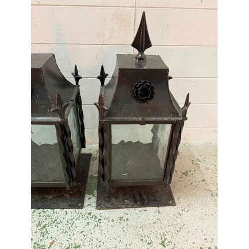 229 - Four wrought iron coach house wall mounted lanterns and one matching wall hanging lantern