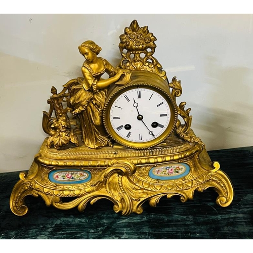 394 - A gilt bronze mantel clock with figural surmount, in set with serves style floral painted panels tog... 