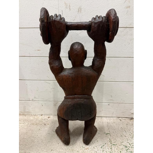 409 - A South African hardwood carving of a weight lifter H53cm