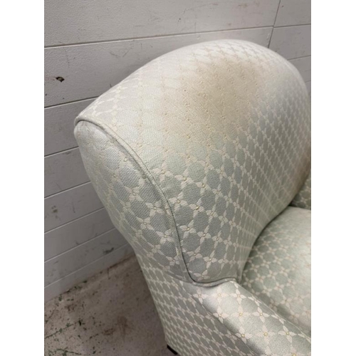 48 - A lounge chair and matching foot stool upholstered in pale green