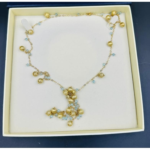 570 - An 18ct gold necklace with interspaced balls and aquamarine style stones and an approximate weight o... 