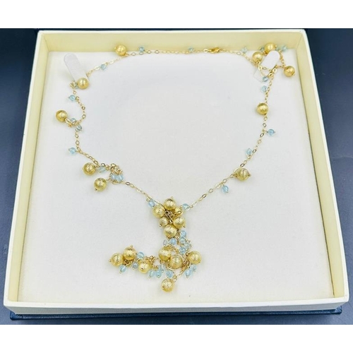 570 - An 18ct gold necklace with interspaced balls and aquamarine style stones and an approximate weight o... 