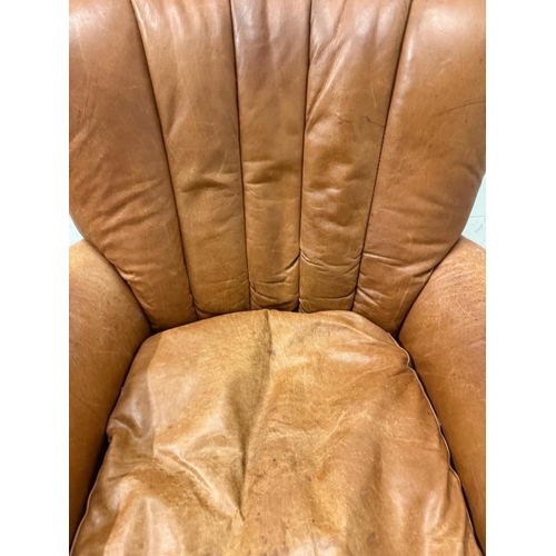 58 - A tan leather upholstered armchair with brass stud detail